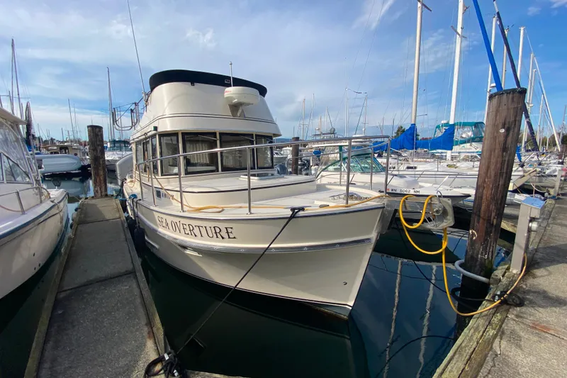 Slide: The Image of Camano 30 boat named "Sea Overture" docked at a marina on a sunny day. - 1