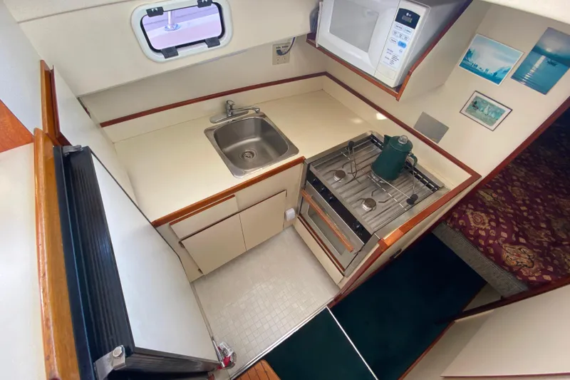 Slide: The Image of Compact kitchen in a Camano 30 boat with stove, sink, and microwave. - 16