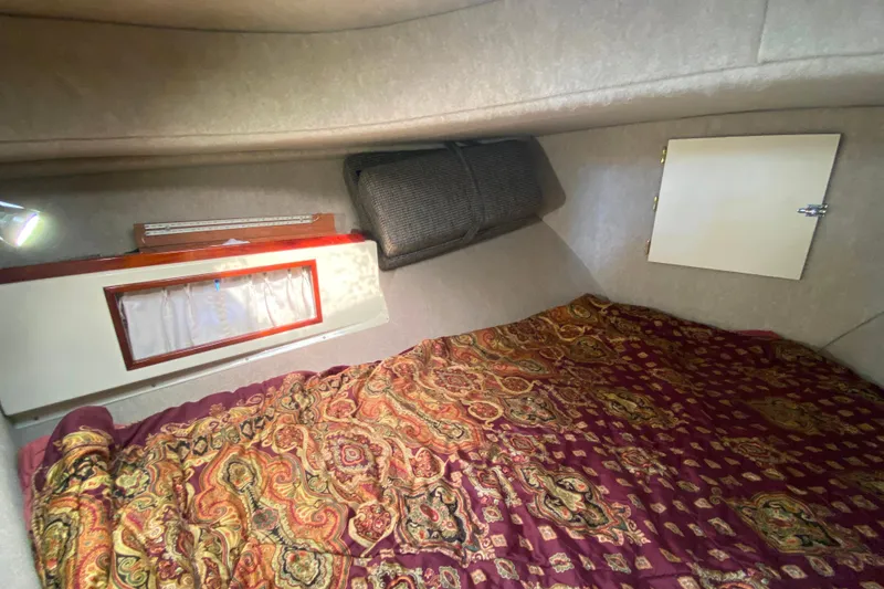 Slide: The Image of Cozy Camano 30 boat cabin with patterned bedding and small window. - 23
