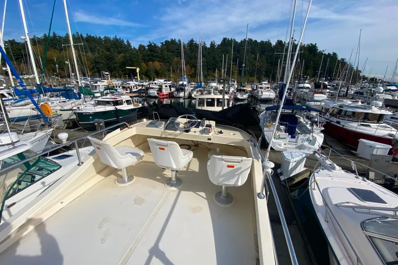 Slide: The Image of Camano 30 boat in a marina, surrounded by various sailboats and yachts under a clear blue sky. - 35