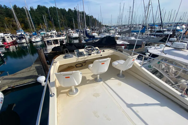 Slide: The Image of Camano 30 boat with helm chairs docked in a marina, surrounded by sailboats. - 36