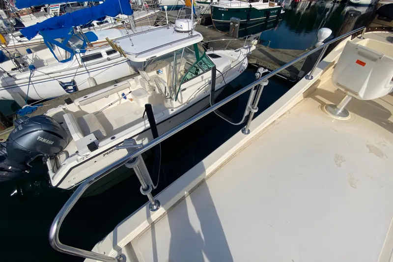 Slide: The Image of Camano 30 boat docked at marina, viewed from above, with nearby vessels. - 39