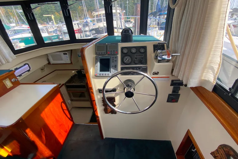 Slide: The Image of Interior helm of a Camano 30 boat with steering wheel and navigation controls. - 9