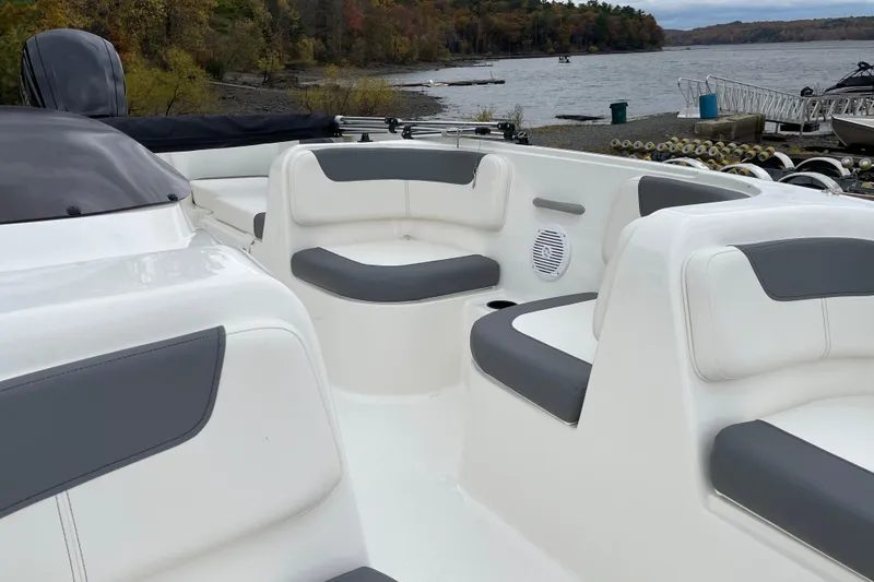 Slide: The Image of 2026 Bayliner Element E18 boat interior with white and gray seating by a lake. - 10