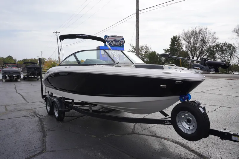Slide: The Image of 2026 Chaparral 21 SSi Ski & Fish boat on trailer, parked outdoors. - 2