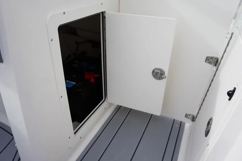 Slide: The Image of 2026 Chaparral 21 SSi Ski & Fish boat storage compartment with open door. - 21