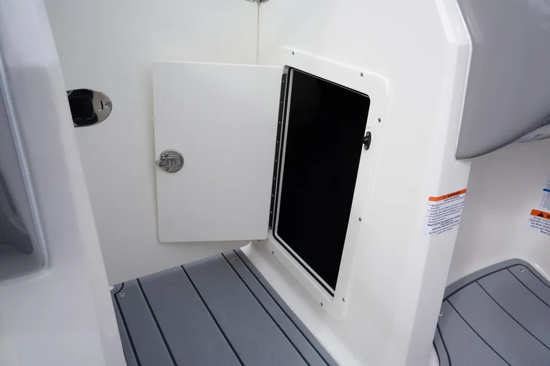 Slide: The Image of 2026 Chaparral 21 SSi Ski & Fish boat storage compartment with open hatch. - 22