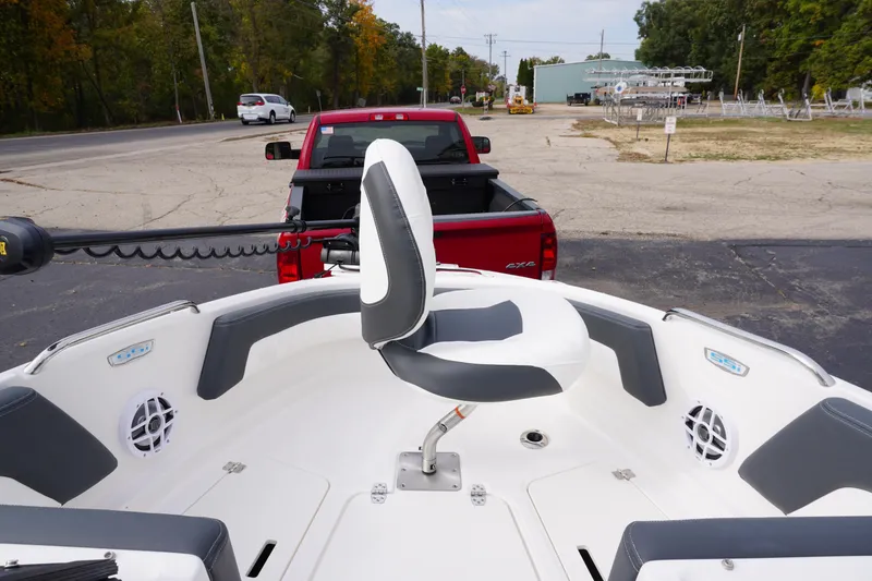 Slide: The Image of 2026 Chaparral 21 SSi Ski & Fish boat interior with fishing seat, parked near red truck. - 27