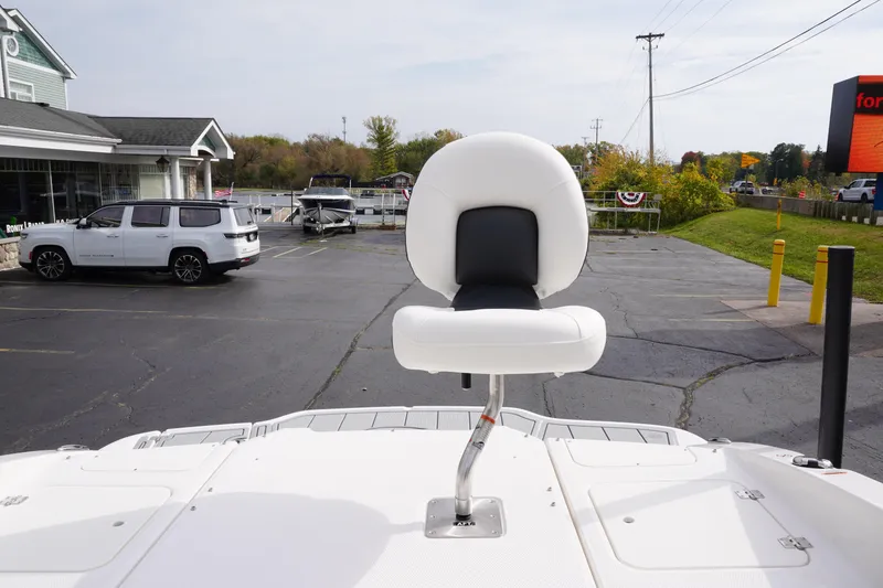 Slide: The Image of 2026 Chaparral 21 SSi Ski & Fish boat seat, parked in a lot with vehicles and greenery. - 57