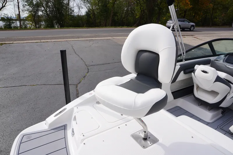 Slide: The Image of 2026 Chaparral 21 SSi Ski & Fish boat with swivel seating, docked near a road. - 58