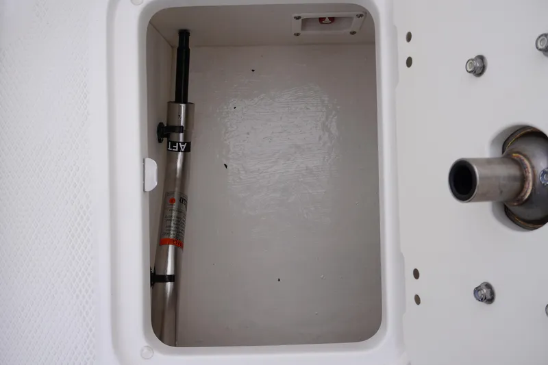 Slide: The Image of Storage compartment of 2026 Chaparral 21 SSi Ski & Fish boat, featuring hydraulic components. - 59