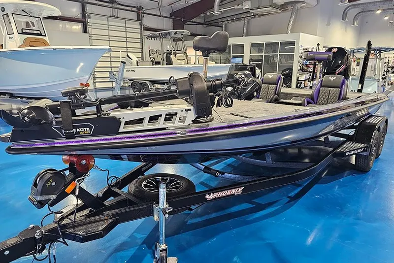 Slide: The Image of 2026 Phoenix 721 ZXL bass boat on trailer in showroom setting. - 5