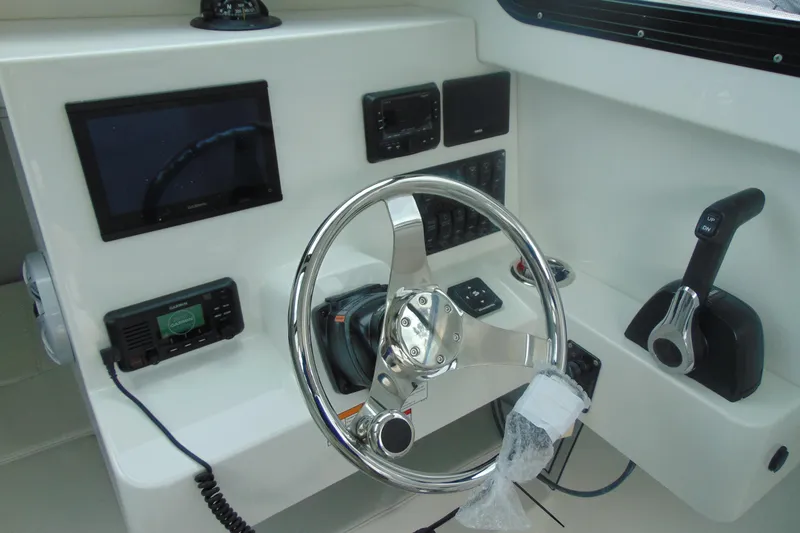 Slide: The Image of 2026 Parker 227 Explorer boat dashboard with steering wheel and navigation controls. - 14