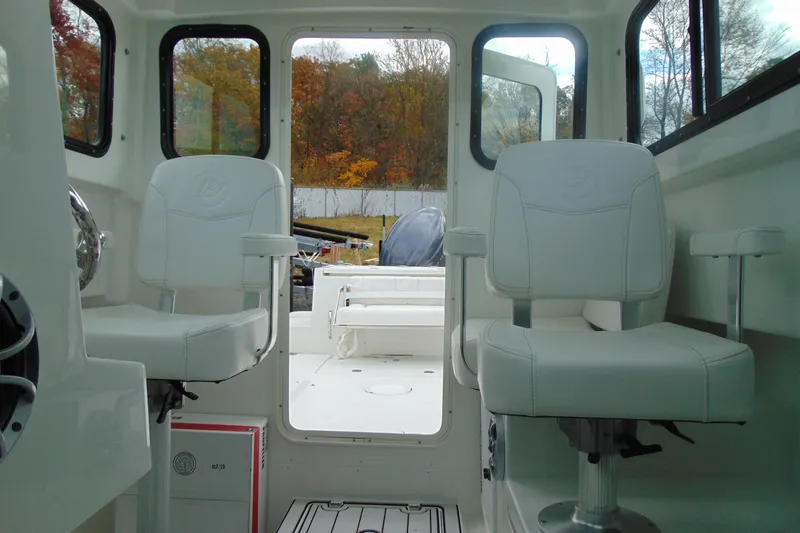 Slide: The Image of Interior of 2026 Parker 227 Explorer boat with white seating and windows. - 18