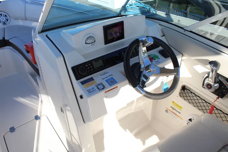 Slide: The Image of 2024 Sailfish 226DC boat cockpit with steering wheel, control panel, and navigation equipment. - 18