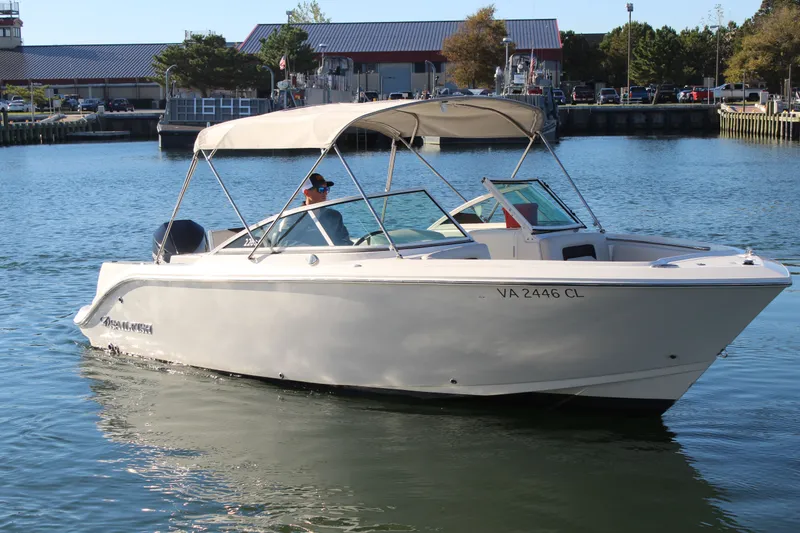 Slide: The Image of 2024 Sailfish 226DC boat cruising in a marina with a canopy. - 4