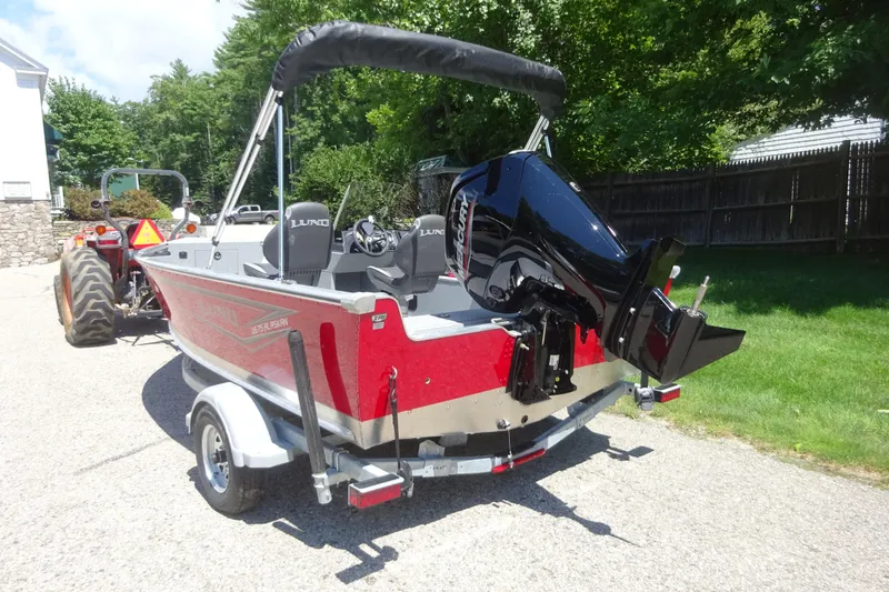 Slide: The Image of 2024 Lund 1675 Alaskan SS boat on trailer, featuring a powerful outboard motor. - 2