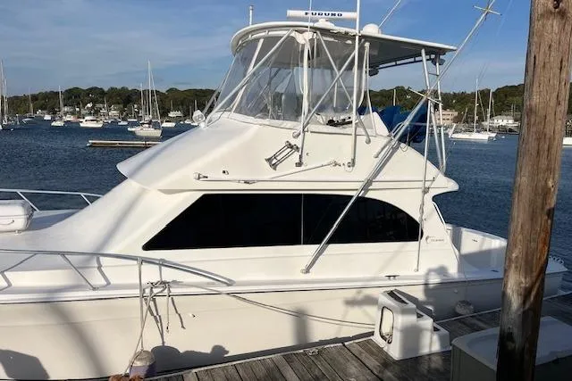 Slide: The Image of 2001 Egg Harbor 42 SportYacht docked at marina, surrounded by calm waters and other boats. - 2