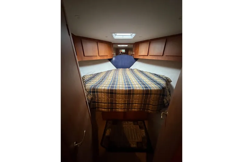 Slide: The Image of Cozy cabin interior of 2001 Egg Harbor 42 SportYacht with plaid bedding and wooden cabinets. - 26