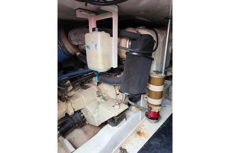 Slide: The Image of Engine compartment of a 2001 Egg Harbor 42 SportYacht, showcasing mechanical components and hoses. - 37