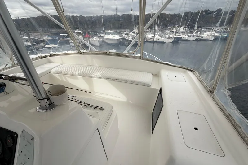 Slide: The Image of 2001 Egg Harbor 42 SportYacht interior with marina view, featuring white seating and helm controls. - 7