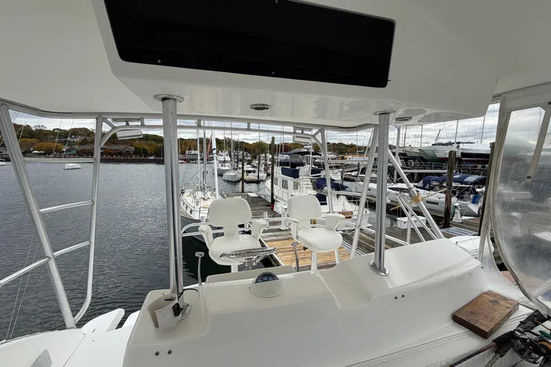Slide: The Image of 2001 Egg Harbor 42 SportYacht interior view at marina, showcasing helm and seating area. - 8