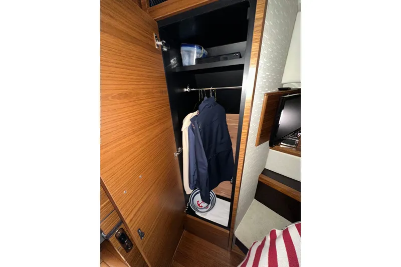 Slide: The Image of 2018 Tiara Yachts C39 Coupe interior closet with wooden finish and hanging clothes. - 30