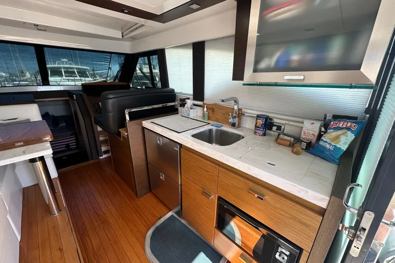 Slide: The Image of Interior of 2018 Tiara Yachts C39 Coupe with modern kitchen and wooden flooring. - 9