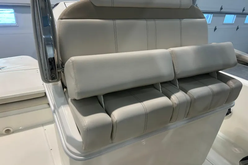 Slide: The Image of 2025 Boston Whaler 220 Dauntless boat seat with beige upholstery in a garage setting. - 16