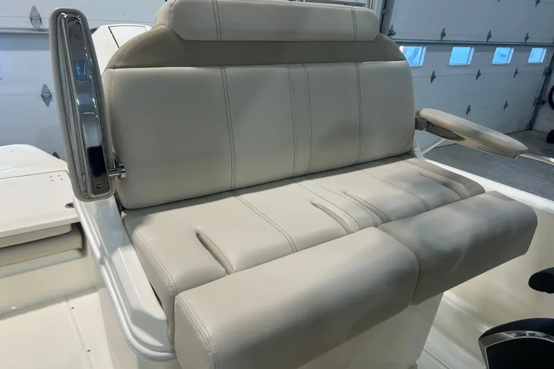 Slide: The Image of 2025 Boston Whaler 220 Dauntless boat seat, beige upholstery, in a garage setting. - 17