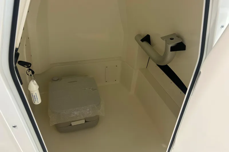 Slide: The Image of Interior of 2025 Boston Whaler 220 Dauntless boat with portable toilet and storage space. - 21