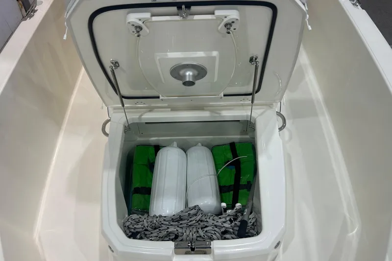 Slide: The Image of Open storage compartment on 2025 Boston Whaler 220 Dauntless, containing fenders and rope. - 26