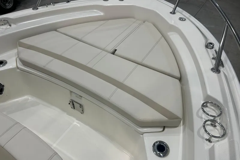 Slide: The Image of 2025 Boston Whaler 220 Dauntless boat interior with cushioned seating and stainless steel fixtures. - 27