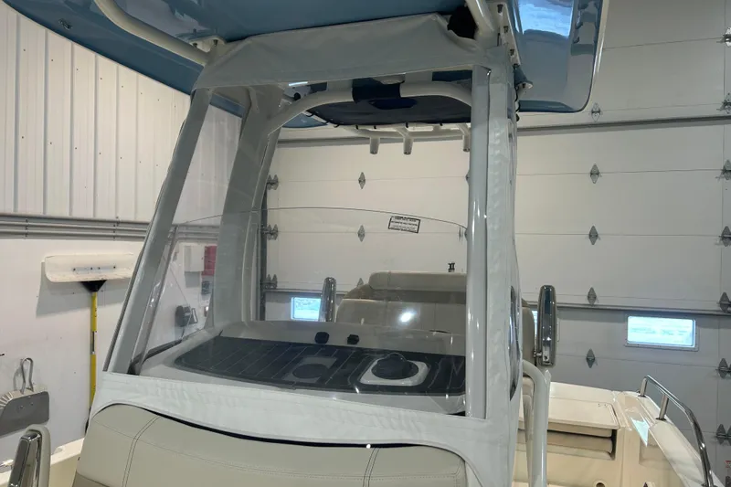 Slide: The Image of 2025 Boston Whaler 220 Dauntless boat interior with protective enclosure in a garage setting. - 29