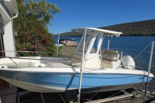 Slide: The Image of 2025 Boston Whaler 220 Dauntless boat docked by a scenic lake. - 31