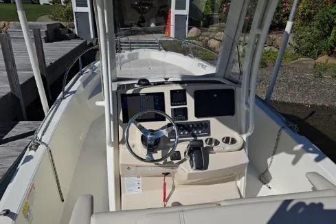 Slide: The Image of 2025 Boston Whaler 220 Dauntless boat in a garage, showcasing sleek design and blue hull. - 5