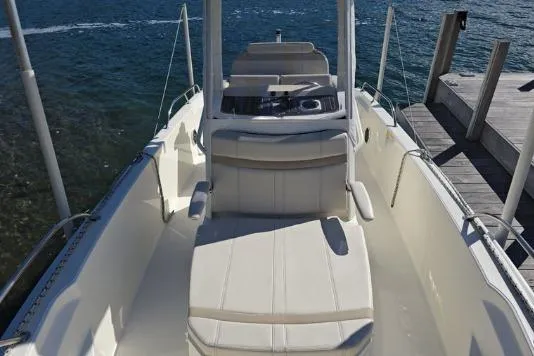 Slide: The Image of 2025 Boston Whaler 220 Dauntless boat interior with seating, in a garage setting. - 6