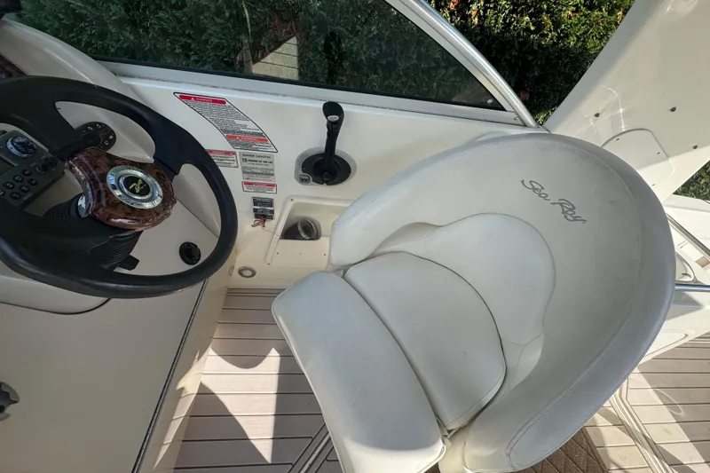 Slide: The Image of 2004 Sea Ray 260 Sundancer helm with steering wheel and captain's chair. - 5