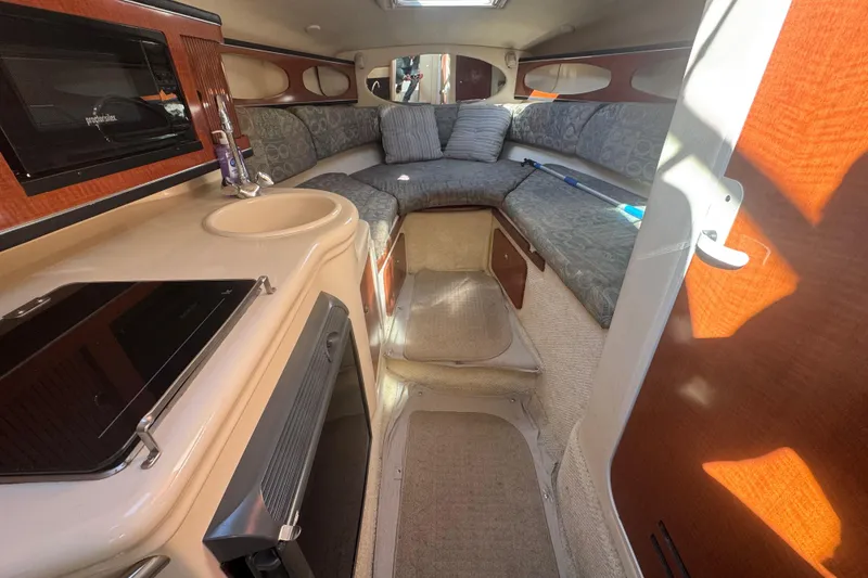 Slide: The Image of Interior of 2004 Sea Ray 260 Sundancer boat with kitchenette and seating area. - 7
