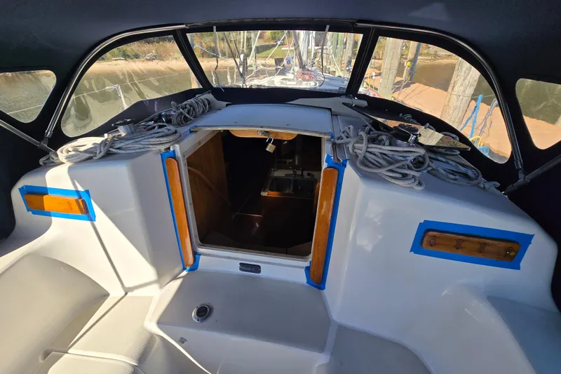 Slide: The Image of 1988 Pearson 362 Centerboard sailboat cockpit with ropes and open cabin entrance. - 10
