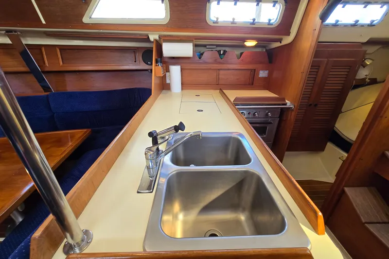 Slide: The Image of 1988 Pearson 362 Centerboard yacht interior with dual sink, stove, and wooden cabinetry. - 14