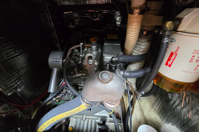 Slide: The Image of Engine compartment of a 1988 Pearson 365 Centerboard sailboat, featuring hoses and a fuel filter. - 19