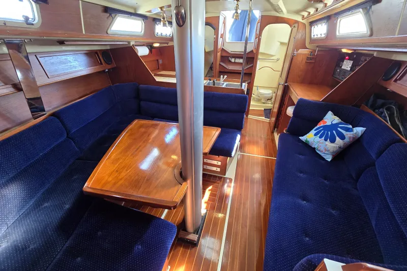 Slide: The Image of Interior of a 1988 Pearson 362 Centerboard sailboat with blue seating and wooden table. - 24