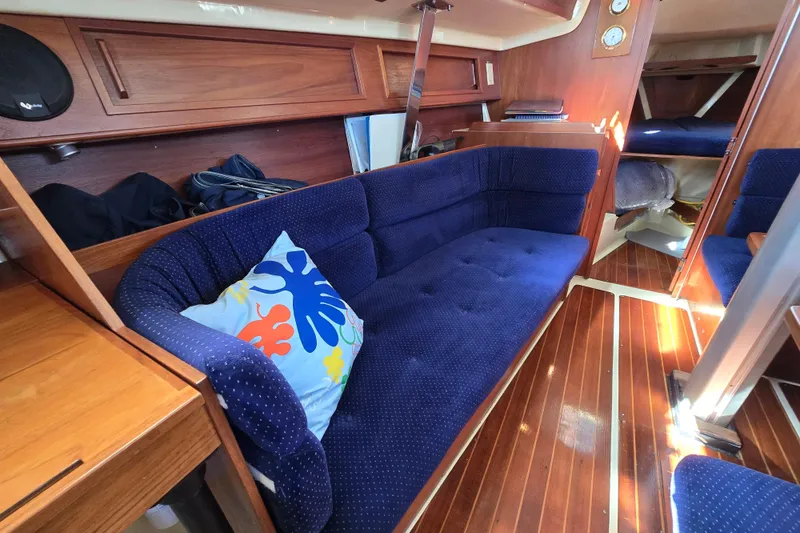 Slide: The Image of Interior of 1988 Pearson 362 Centerboard sailboat with blue cushioned seating and wooden flooring. - 5