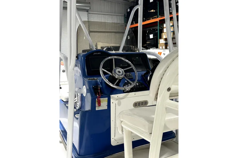 Slide: The Image of Interior view of a 2019 Polar 1 boat, featuring a blue helm and steering wheel. - 7