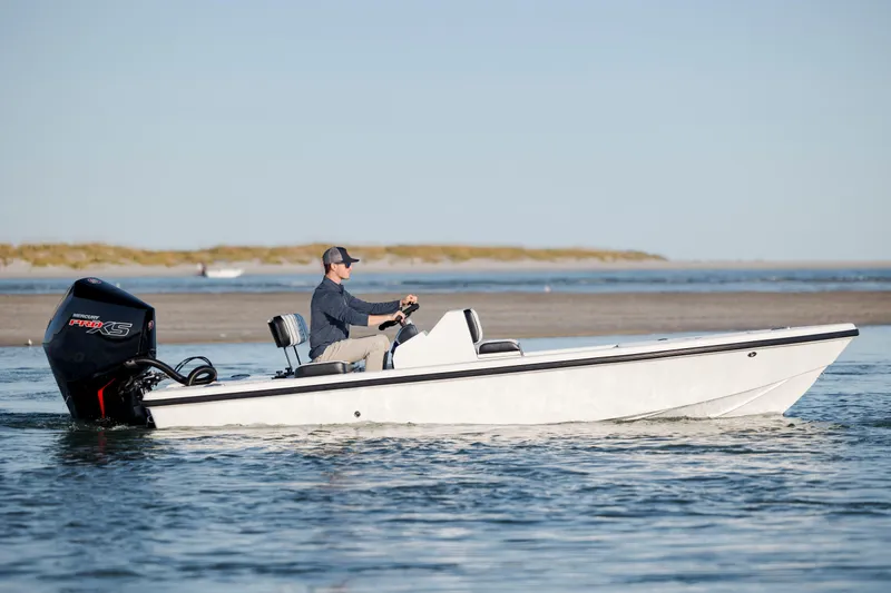 Slide: The Image of A person operates a 2026 Vtech 18 boat with a Mercury Pro XS engine on calm waters. - 7
