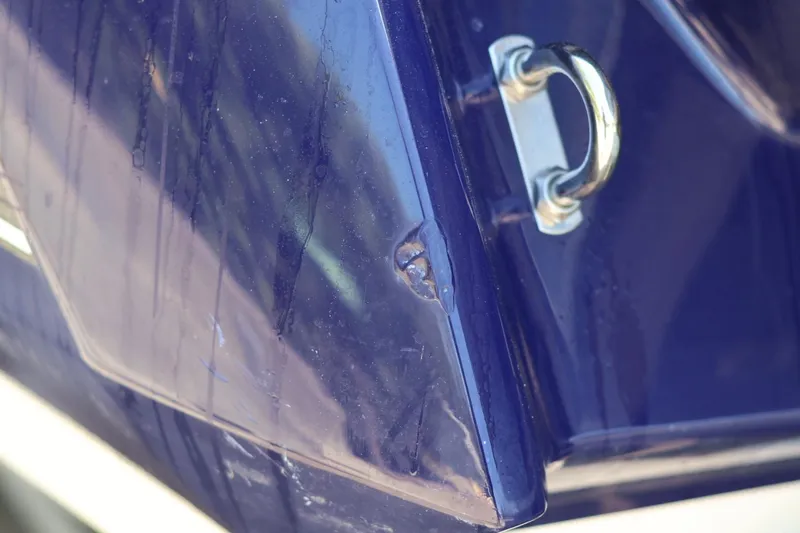 Slide: The Image of Close-up of a 2010 Monterey 254FS boat hull with visible scratches and metal fitting. - 20