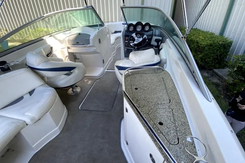 Slide: The Image of 2010 Monterey 254FS boat interior with seating, steering wheel, and granite countertop. - 25