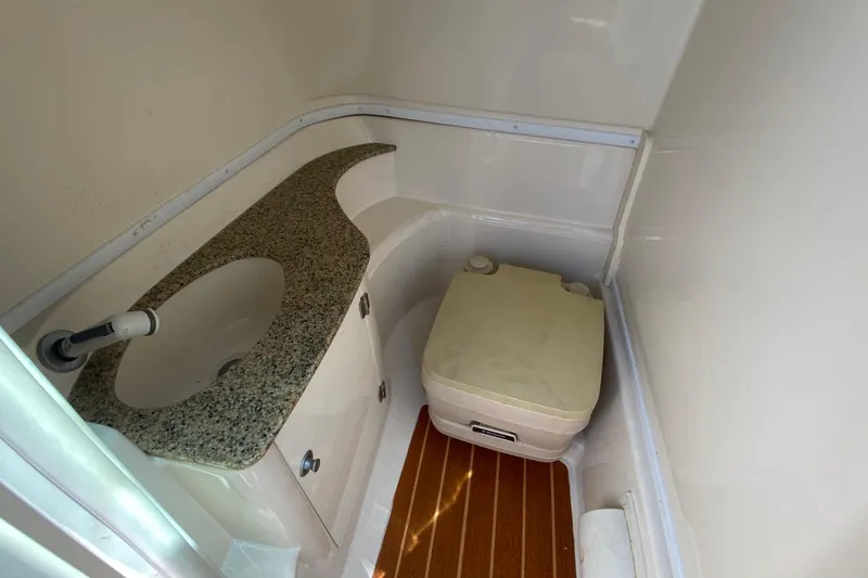 Slide: The Image of 2010 Monterey 254FS boat bathroom with sink, portable toilet, and wooden flooring. - 33
