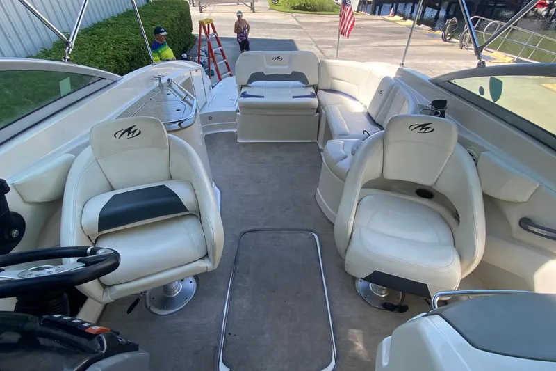 Slide: The Image of 2010 Monterey 254FS boat interior with white seating and steering wheel. - 36